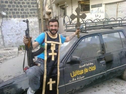 Un ribelle mostra una croce e i paramenti sacri rubati da una chiesa di Homs